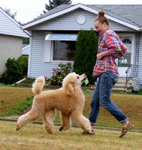 A woman and her poodle having fun